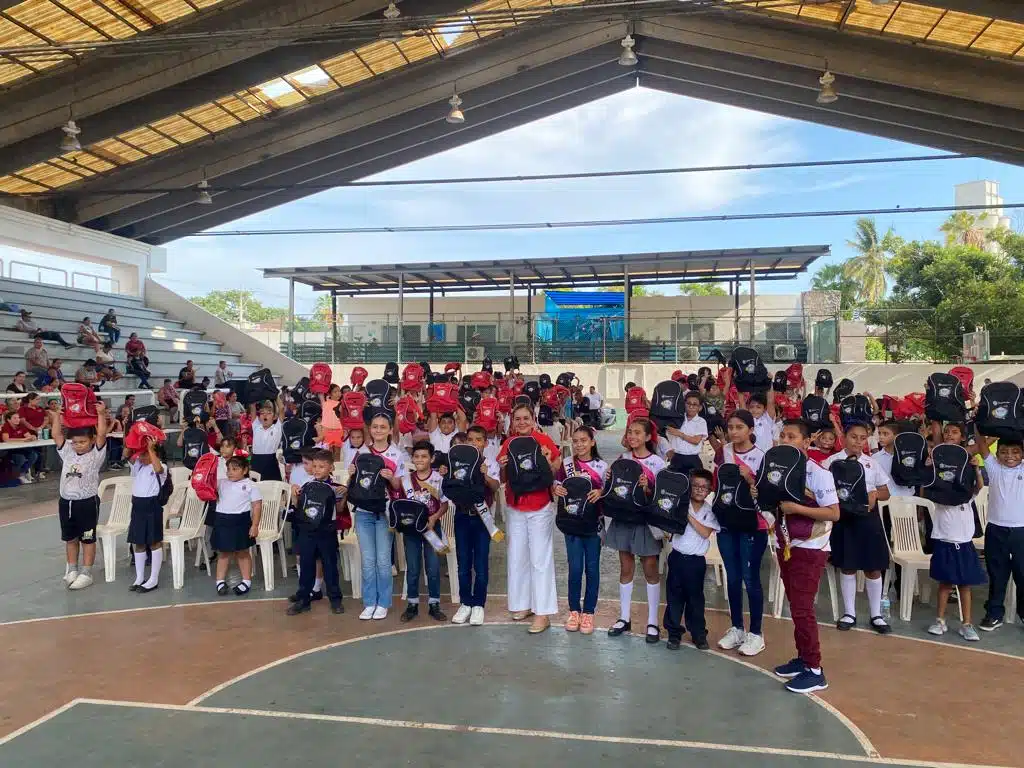 María Teresa Apodaca Muñoz, presidenta del Sistema DIF municipal, junto a los niños beneficiados en la entrega de mochilas