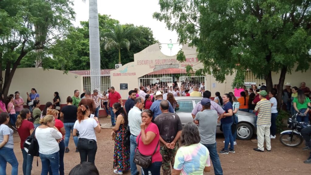 Personas afuera de la Secundaria Técnica 45 de la comunidad de Ocoroni en el municipio de Sinaloa