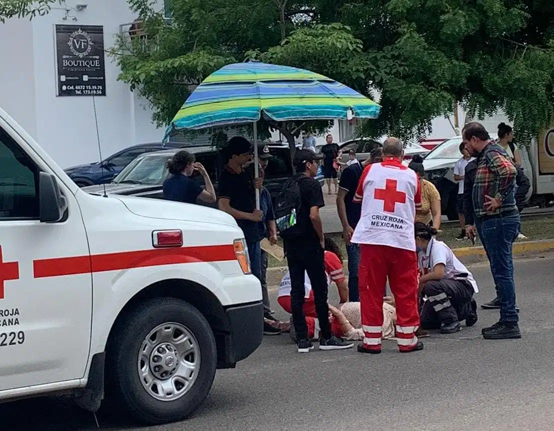 Socorristas de Cruz Roja auxiliando a la persona lesionada que se encuentra en el pavimento