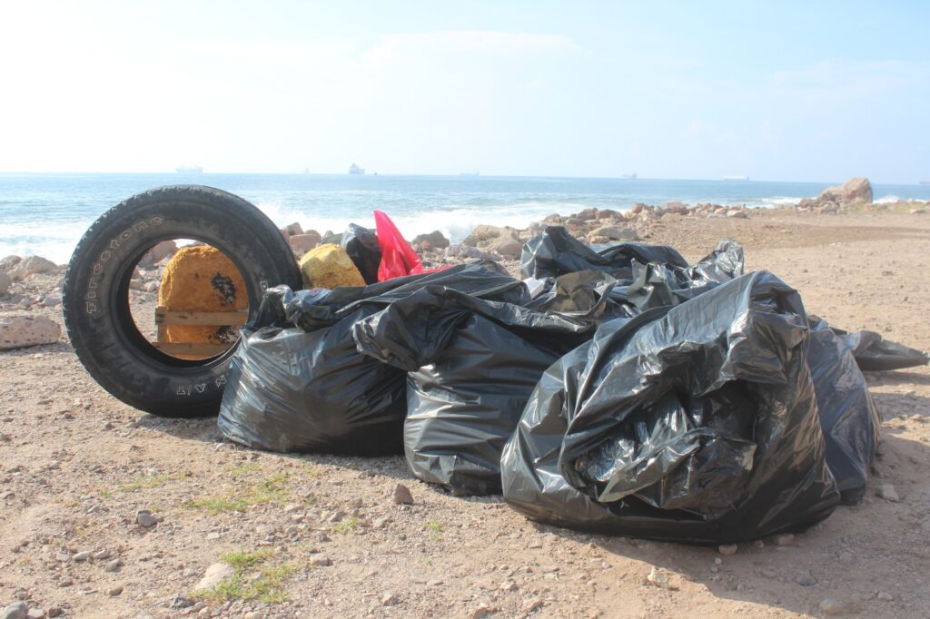 Bolsas negras llenas de basura, desechos y una llanta