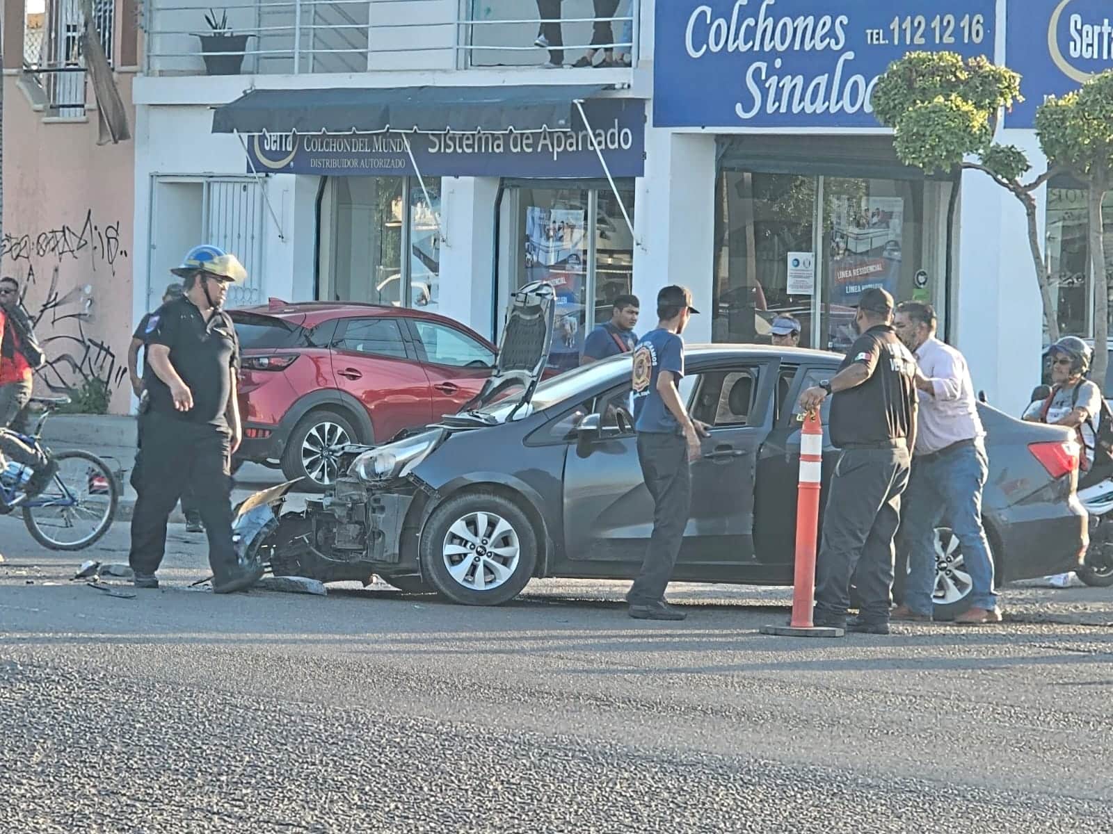 Vehículo con daños en la parte delantera. Hay personas observando