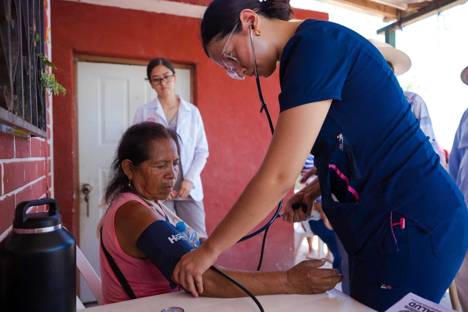 Especialista de la salud checando la presión a una vecina de La Laguna de Oxidación