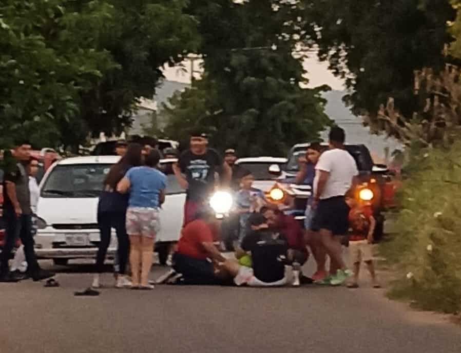 Personas auxiliando al menor que cayó de la camioneta en movimiento