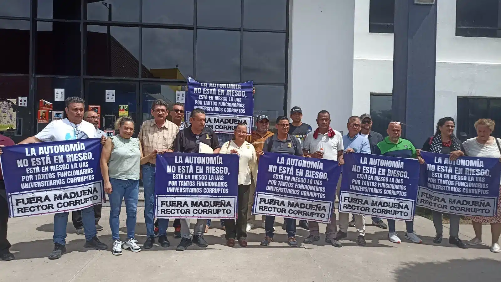 Integrantes del Movimiento Democrático Universitario con pancartas afuera de la Fiscalía