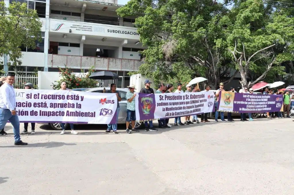 Maestros y alumnos de Facimar sosteniendo pancartas durante su manifestación a las afueras de Semarnat