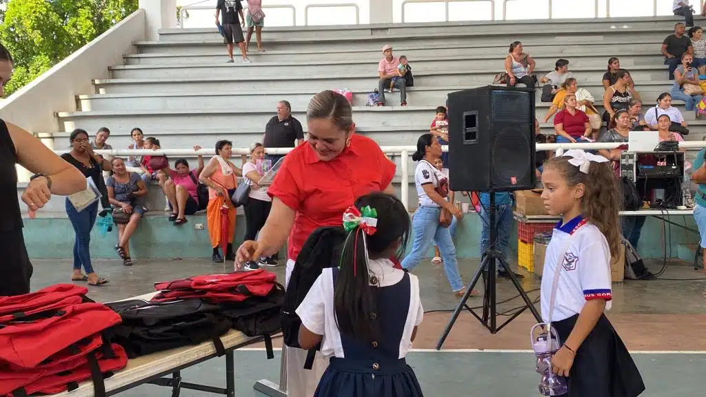 María Teresa Apodaca Muñoz, presidenta del Sistema DIF municipal, junto a los niños beneficiados en la entrega de mochilas