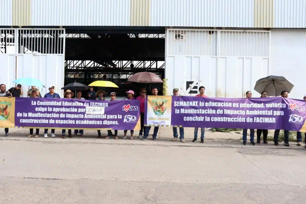 Maestros y alumnos de Facimar sosteniendo pancartas durante su manifestación a las afueras de Semarnat