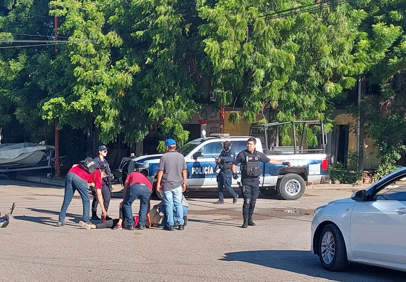 Mujer lesionada rodeada por personas