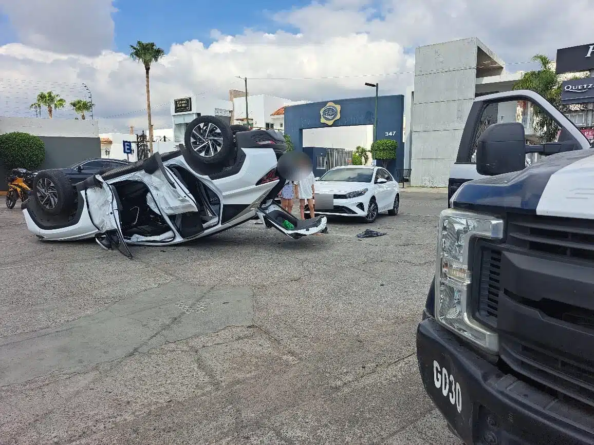 Camioneta volcada con los neumáticos hacia arriba y a un lado un carro chocado