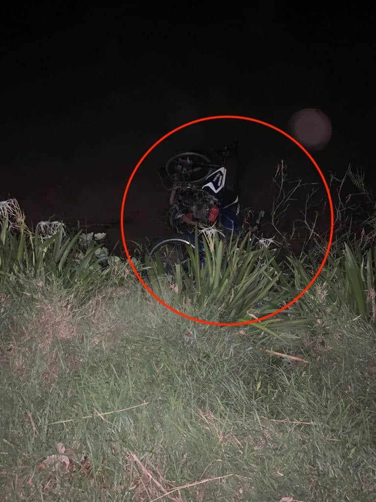 Circulo rojo encerrando la motocicleta que está adentro de un canal con agua