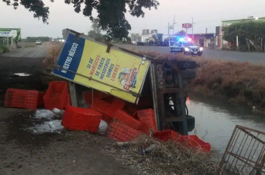 Camión volcado sobre un canal con agua y jabas