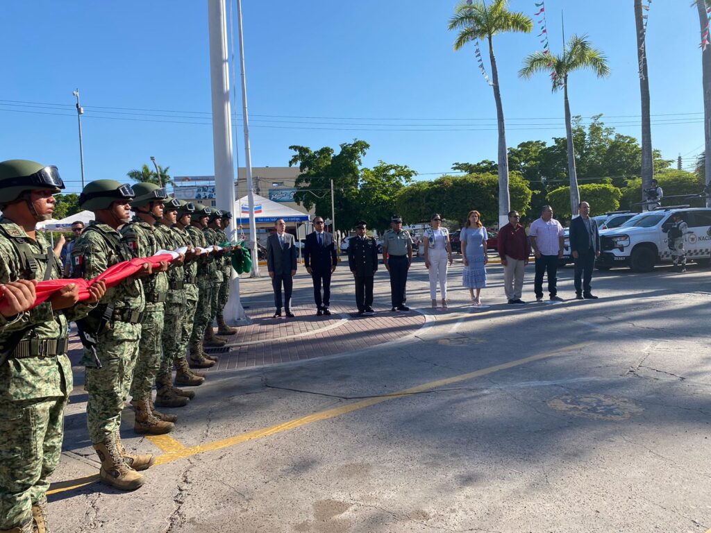 Militares sosteniendo bandera de México