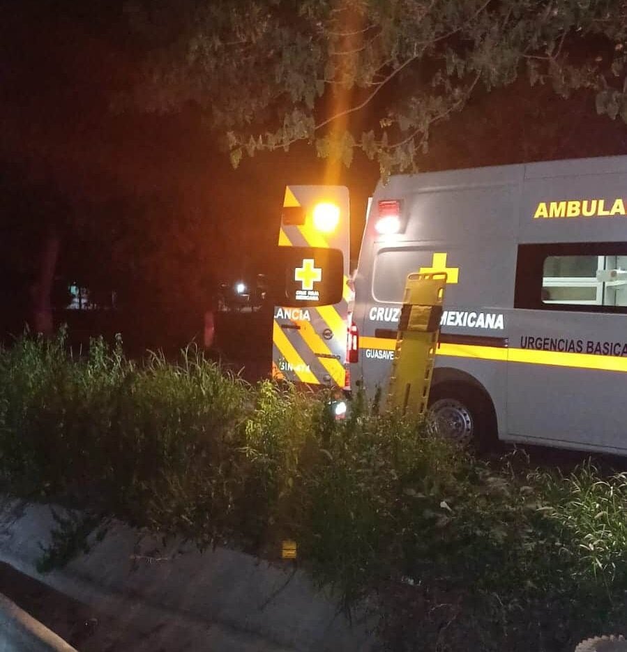 Ambulancia con las puertas traseras abiertas a un lado de un canal