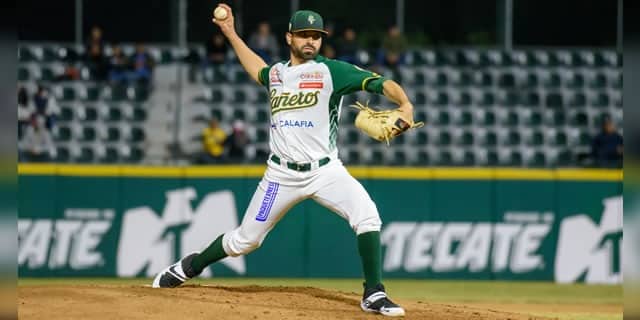 Una persona con uniforme de un equipo de beisbol sobre la lomita del terreno de juego