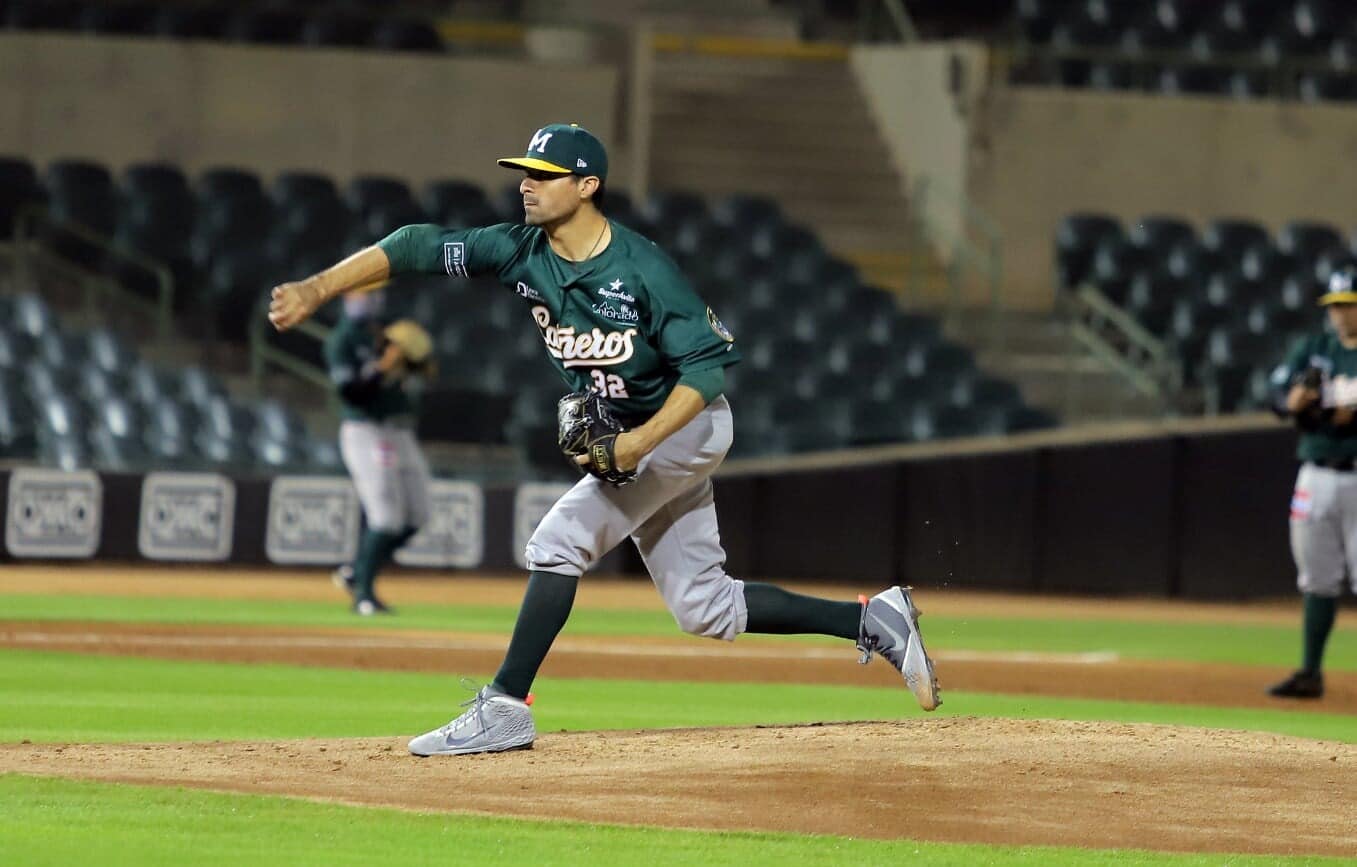 Una persona con uniforme de un equipo de beisbol sobre la lomita del terreno de juego