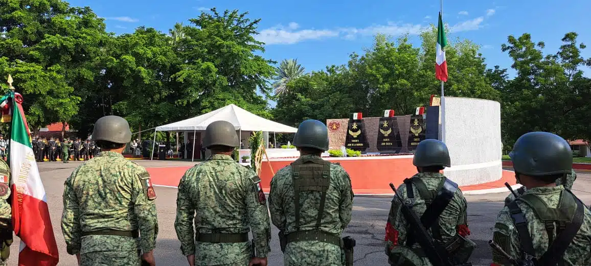 Personas con uniforme de soldados y banderas de México