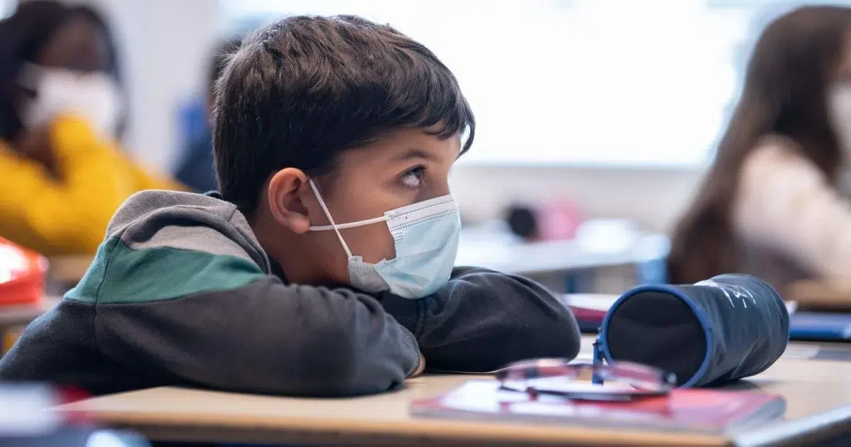 Niño en la escuela con cubrebocas puesto