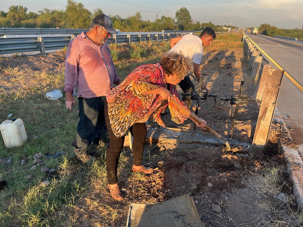 Personas poniendo cruces a la orilla de la carretera