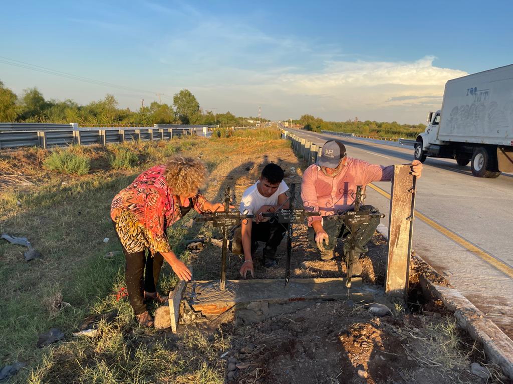 Personas poniendo cruces a la orilla de la carretera