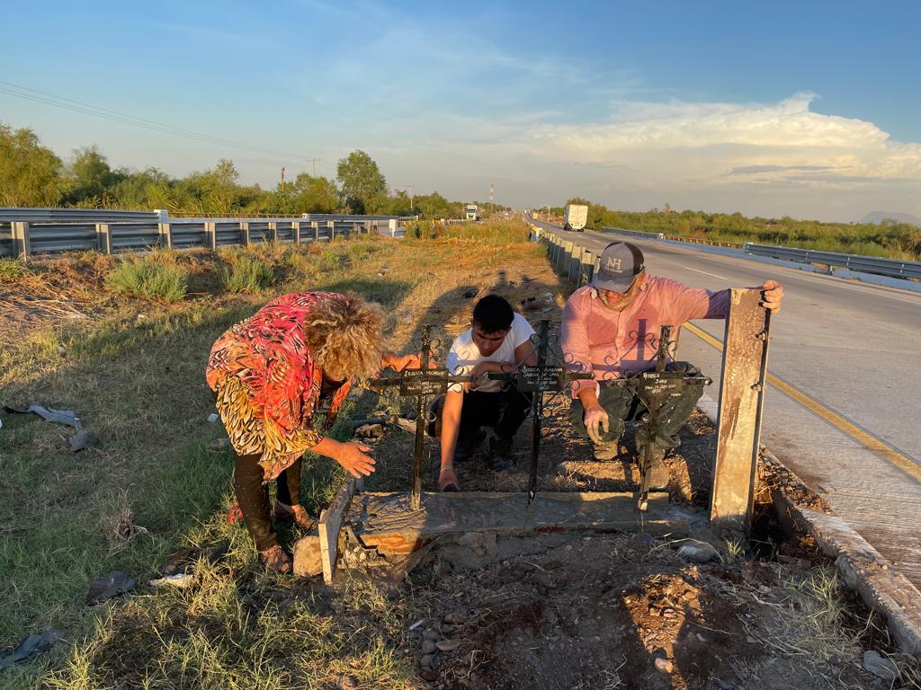 Personas poniendo cruces a la orilla de la carretera