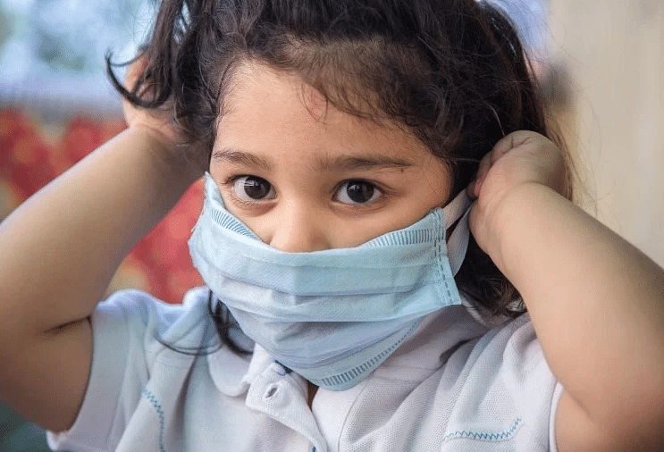 Niña colocándose el cubrebocas