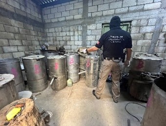 Una persona parada frente a unos tambos