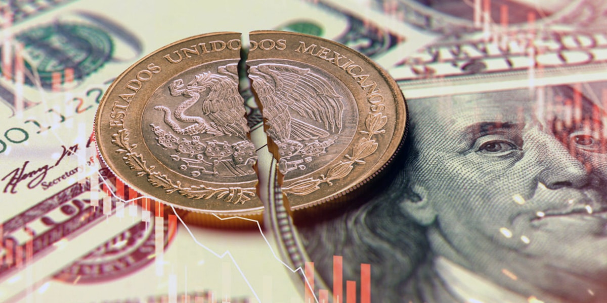 Moneda de 10 pesos partida en dos encima de un billete de 100 dólares