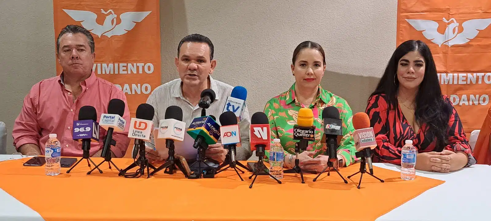 Integrantes de Movimiento Ciudadano sentado con micrófonos de prensa