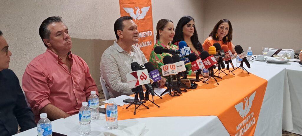 Integrantes de Movimiento Ciudadano sentado con micrófonos de prensa