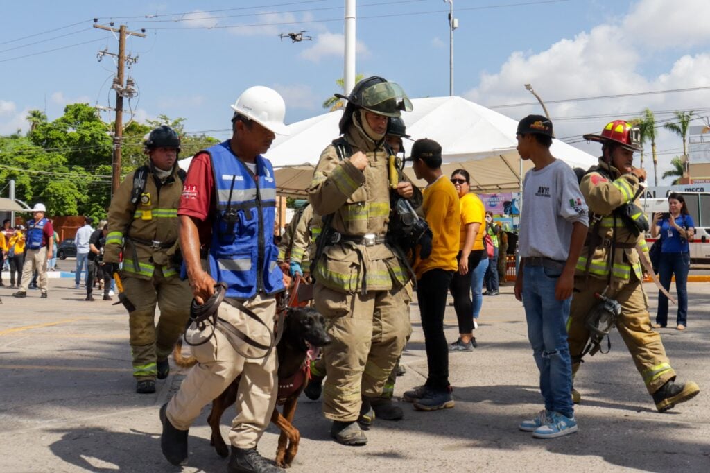 Personal de rescate y perrito entrenado.