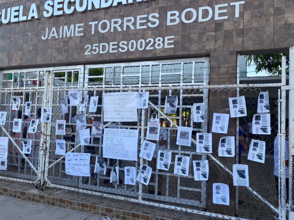 Entrada de una escuela con cartulinas y hojas pegadas