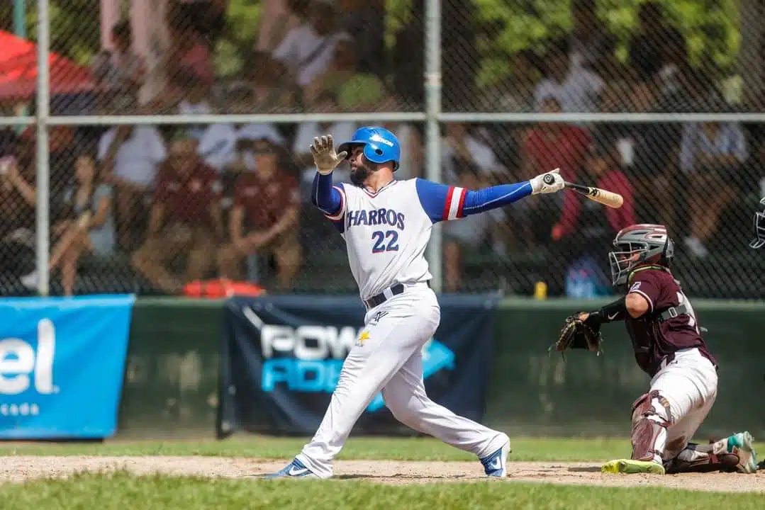 2 personas con uniforme de equipos de beisbol, uno de ellos con bate y el otro con manilla