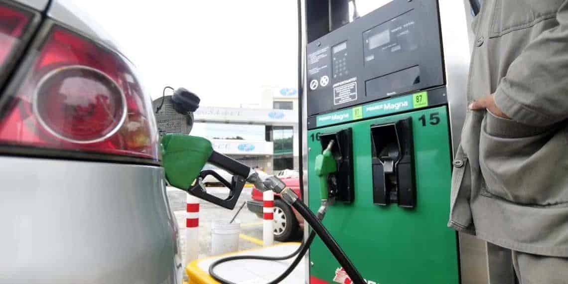 Auto cargando gasolina en la bomba de una estación de servicios
