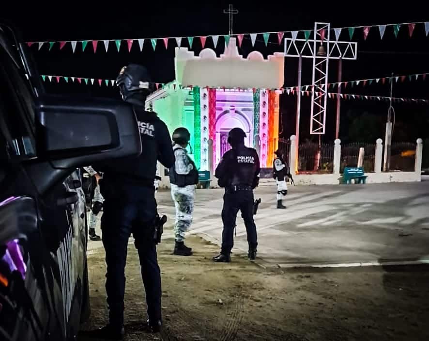 5 personas unas con uniforme de la Guardia Nacional y otras de la policía municipal, y una camioneta
