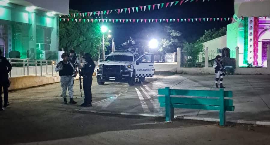 5 personas unas con uniforme de la Guardia Nacional y otras de la policía municipal, y una camioneta
