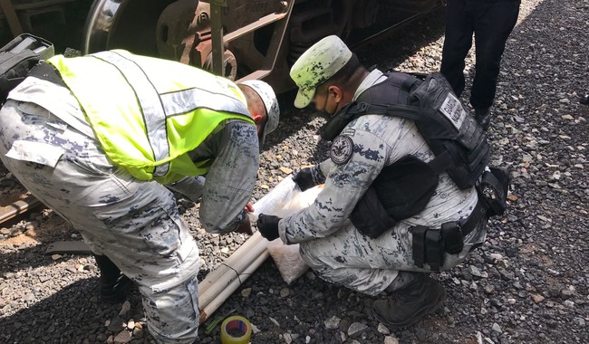 Guardias nacionales con tubos de PCV con droga