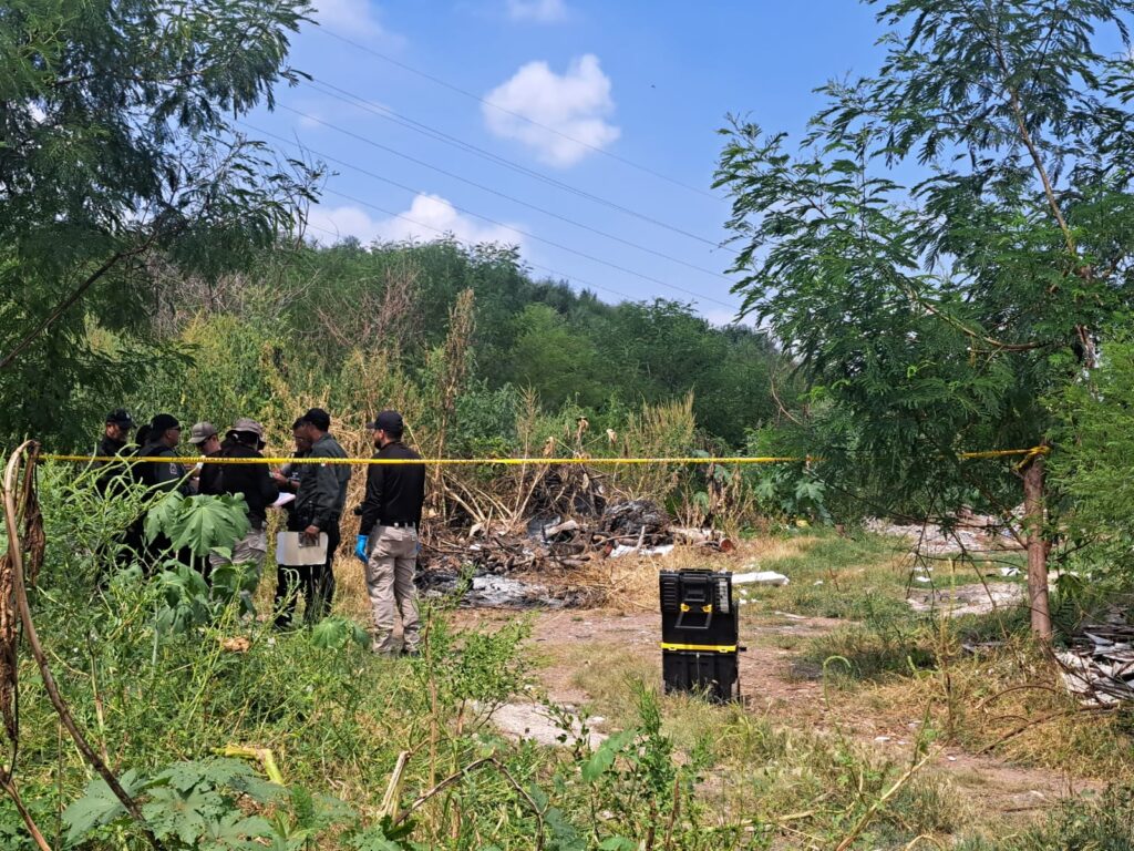 Elementos de la Fiscalía realizan trabajo de investigación en el lugar donde encontraron a un hombre muerto en Culiacán
