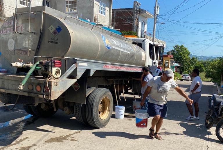 señora cargando cubeta con agua de pipa