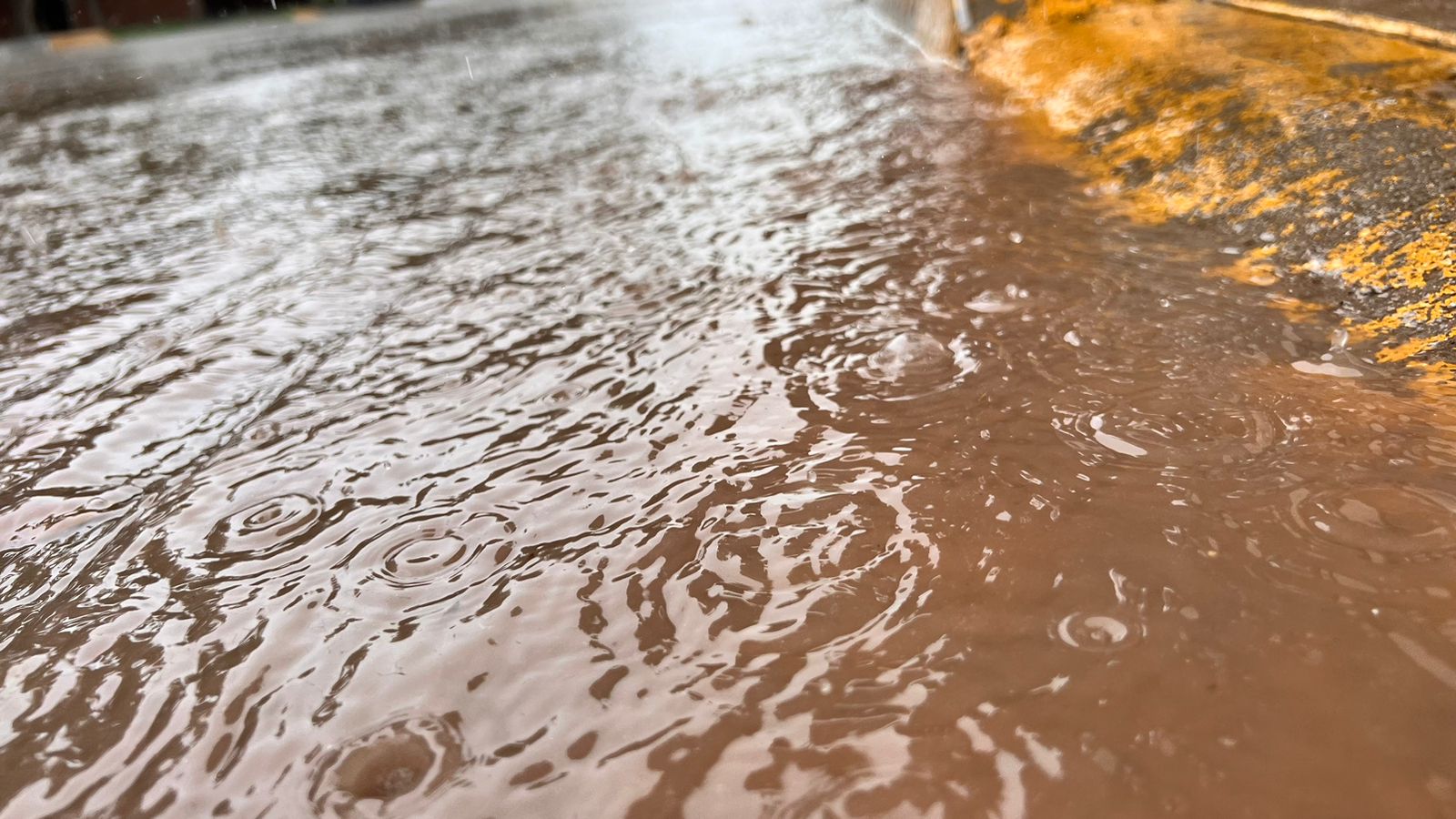 Calle pavimentada encharcada de agua por la lluvia