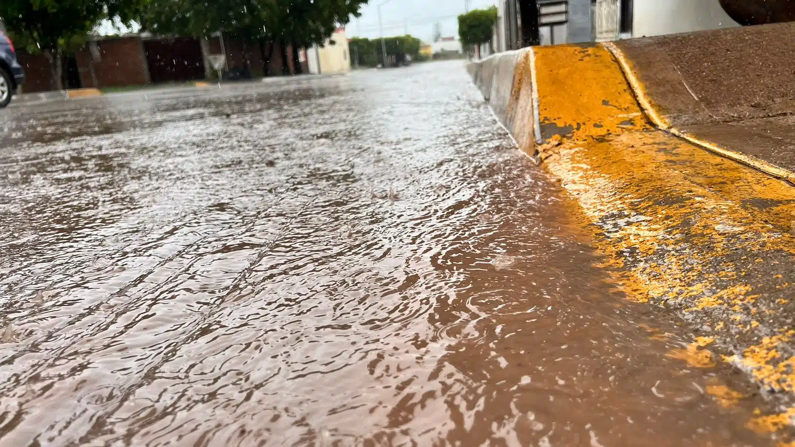 Calle pavimentada encharcada de agua por la lluvia