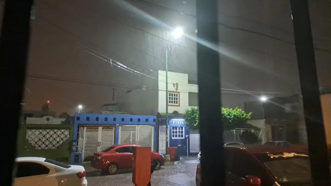 Lluvia moderada, casas, focos y carros