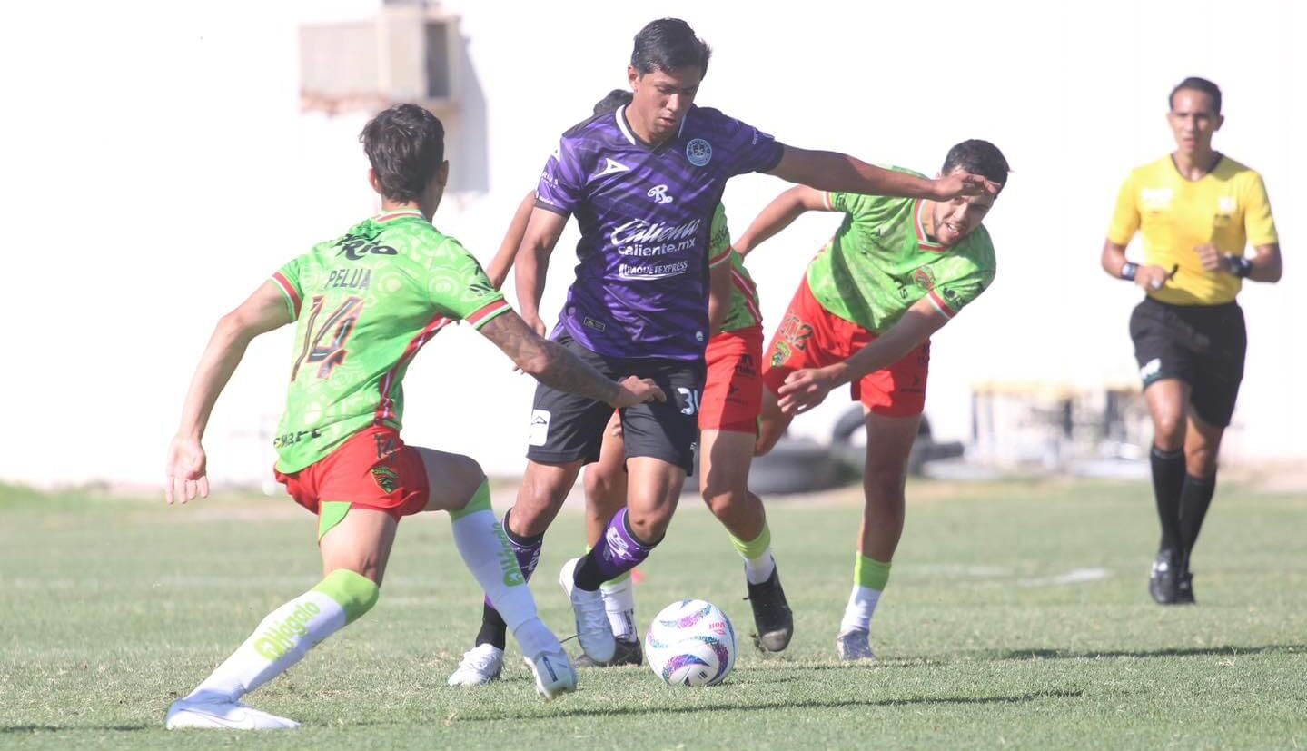 Un jugador del Mazatlán FC conduce el balón e intenta burlar a tres jugadores contrarios.