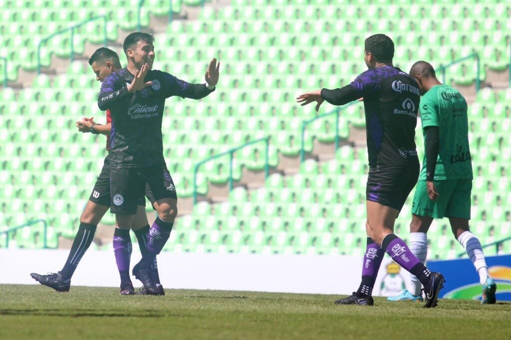 4 personas en una cancha de futbol