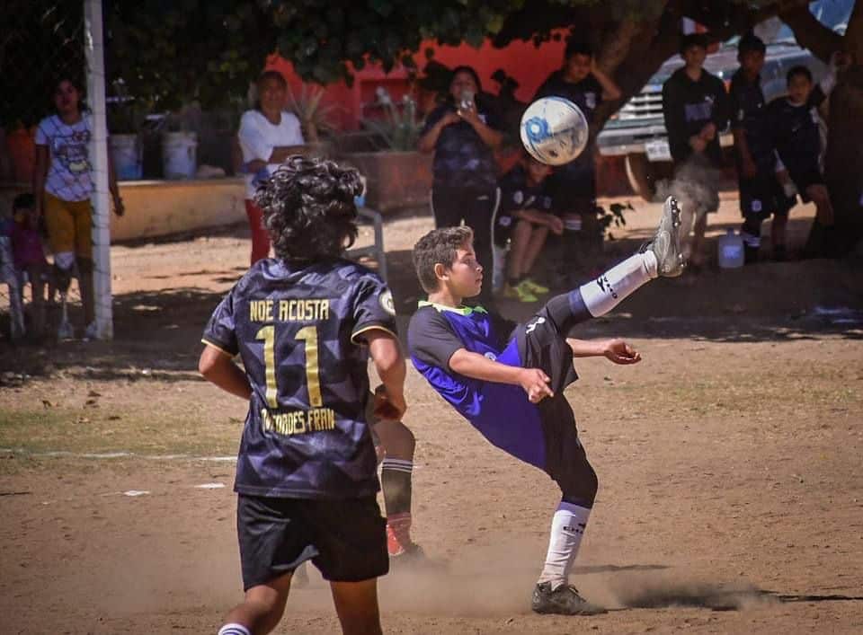 2 niños jugando con una pelota de futbol