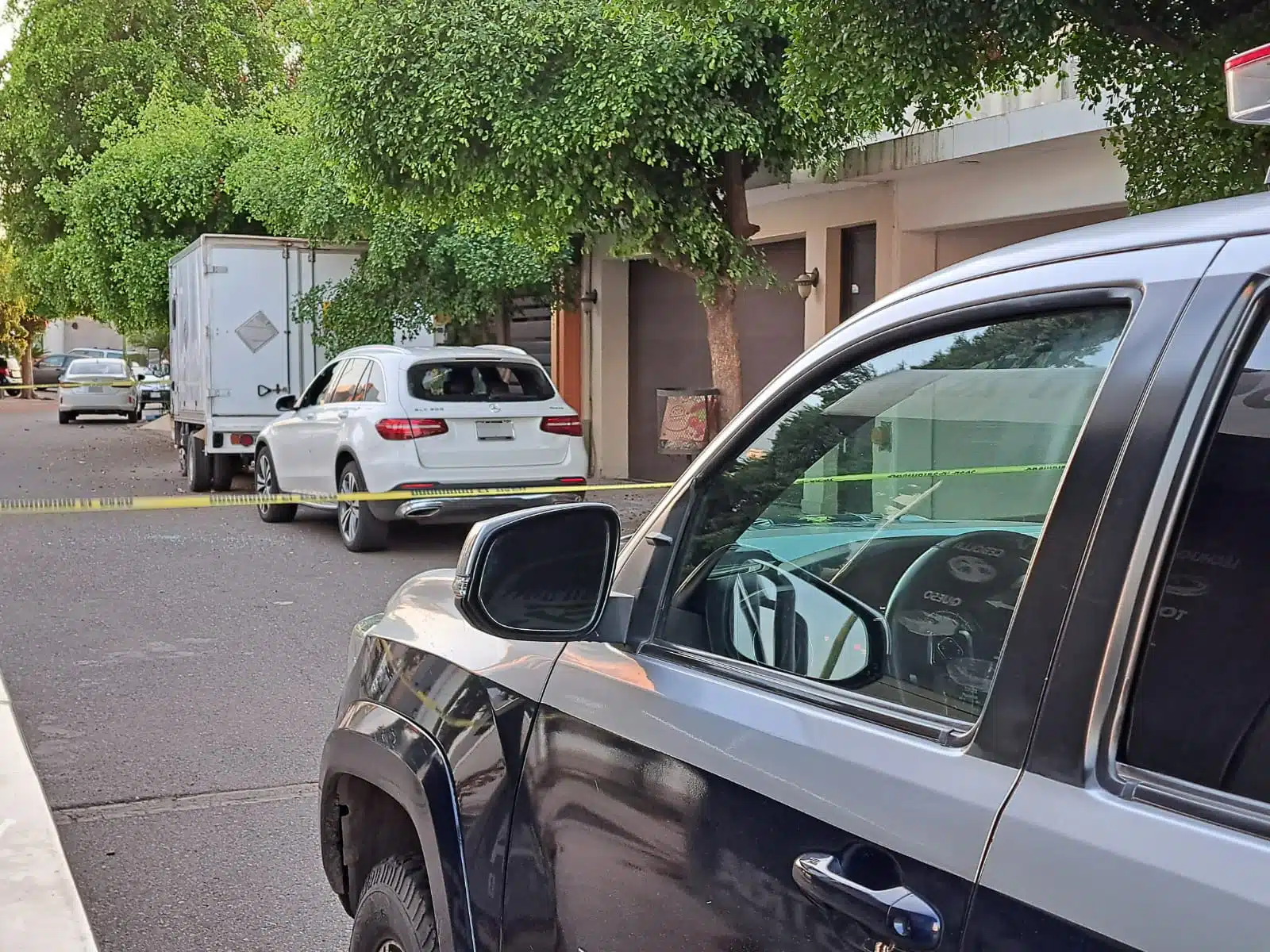 Patrulla municipal y auto Mercedes Benz en escena de un crimen en Culiacán