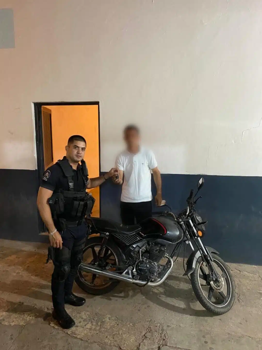 Un agente municipal entrega la motocicleta a su dueño tras recuperarla