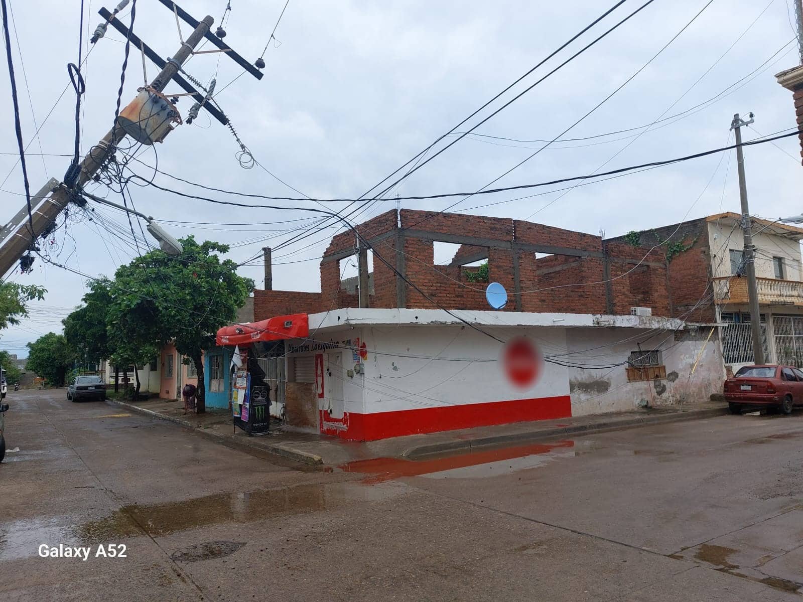 Un poste de la CFE a punto de caerse, casas y árboles