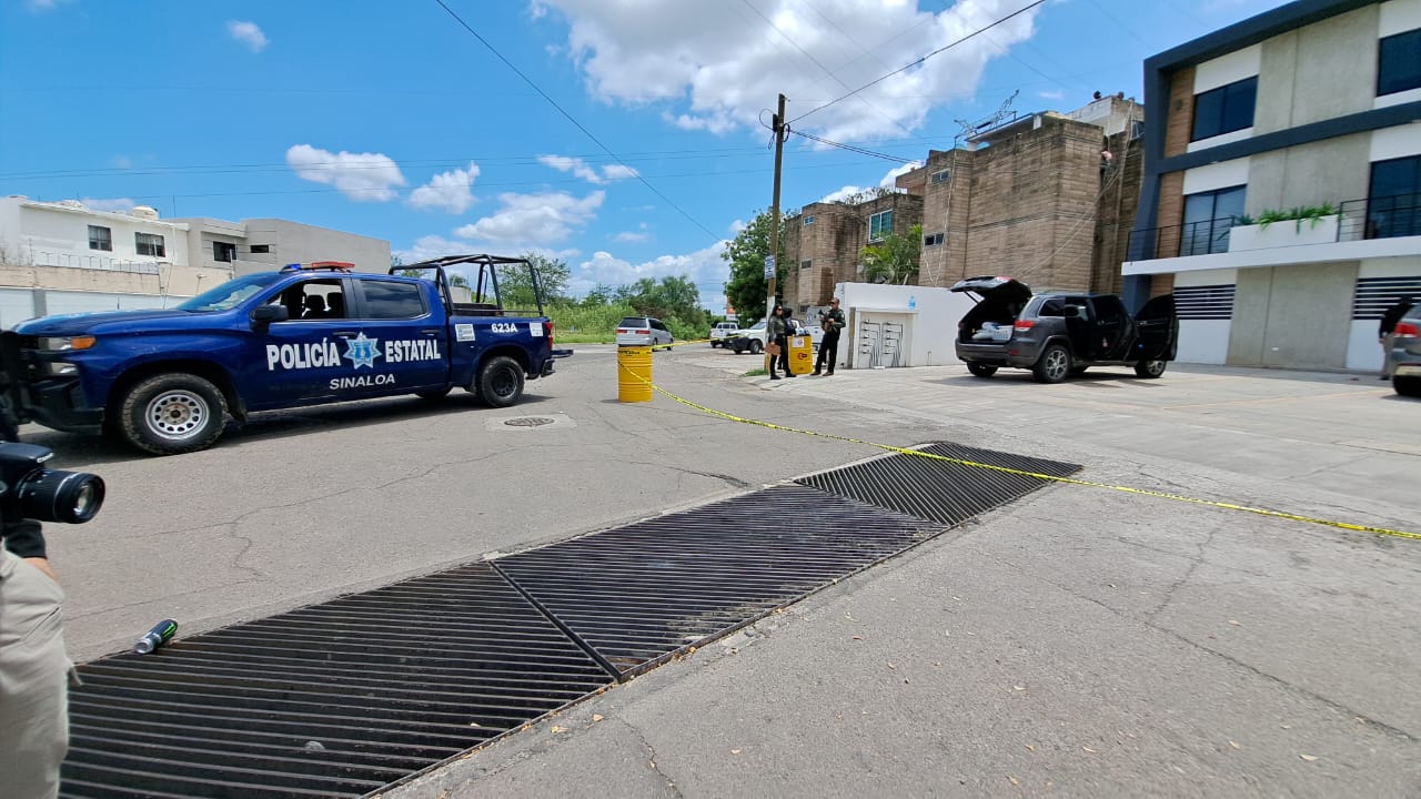 Camioneta de la policía estatal, cinta delimitando un área, camionetas y casas