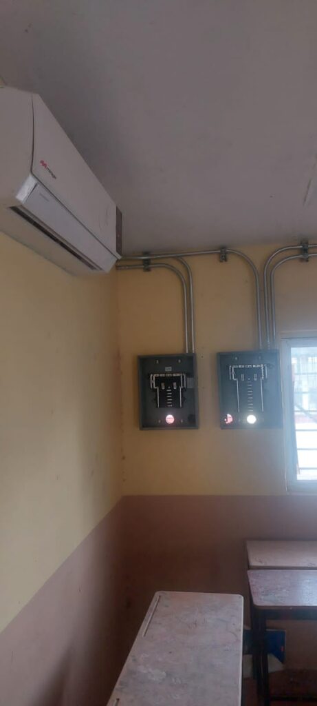 Un aire acondicionado, una caja y tubos por donde pasa la electricidad