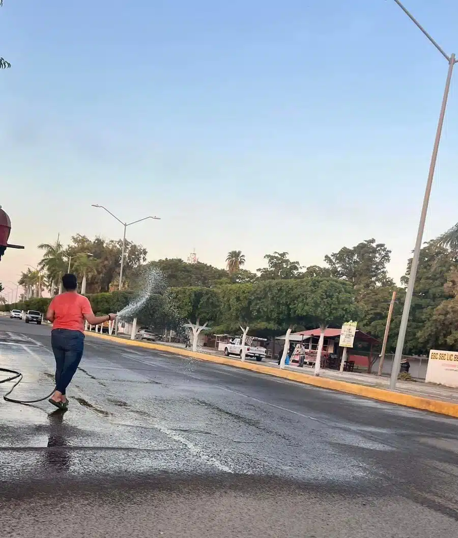 Una de las mujeres captadas tirando agua a la calle en Batamote.